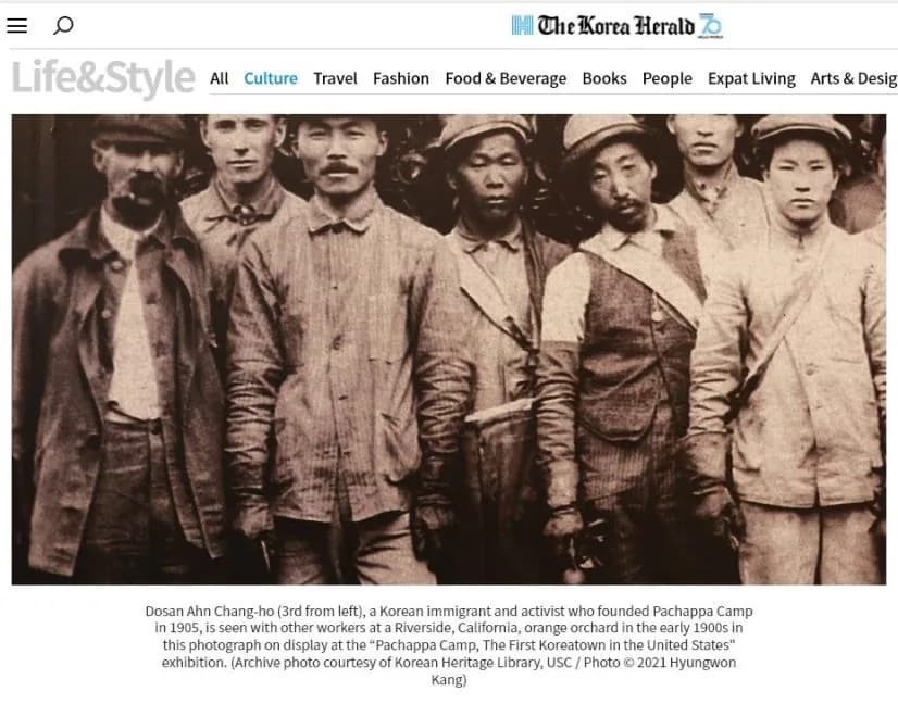 A Korea Herald page showing a sepia crop of seven men from the orchard photograph, above the paper's caption
