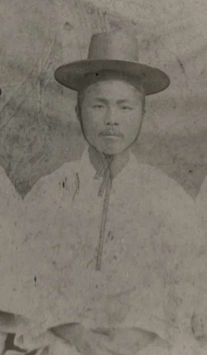Portrait of a young man in a black horsehair hat and a white robe